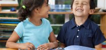 Two delighted kids enjoying a book at school. You may also like: