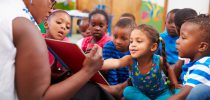 Teacher reading a book with a class of preschool children