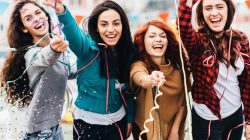 A group of friends throwing conffetti.