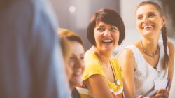 Group of women on seminar. Focus on two laughing women.